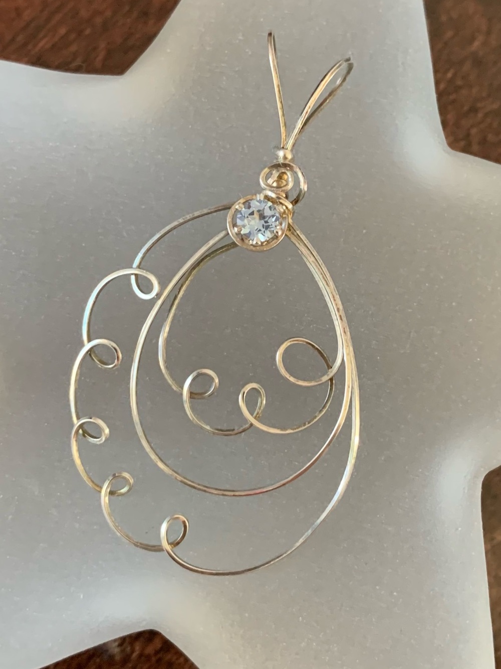 Delicate handmade sterling silver wire pendant with light blue crystal accent